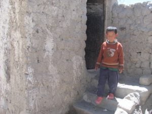 child coming out of dry toilet in Ladakh