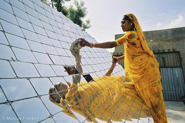 <p>Nightschool of Barefoot College in Tilonia/Rajasthan using solar powered batteries. Woman cleaning solar panels.<br />
Die Nachtschulen des Barefoot College in Tilonia / Rajasthan / Indien koennen nur unterrichten, weil das Barefoot College solar gespeiste Batterie-Laternen zur Verfuegung stellt. Zwei Arbeiterin im Sari am Campus des College in Tilonia, die einen Solar-Ofen zum Kochen saeubert</p>