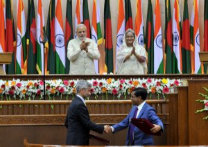 <p>India&#8217;s Prime Minister Narendra Modi (top left) and Bangladesh&#8217;s Prime Minister Sheikh Hasina witness the exchange of agreements between the two countries during Modi&#8217;s recent visit to Dhaka (Image by Press Information Bureau, Government of India)</p>