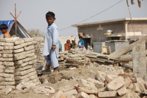 <p>A child stands amongst the remains of buildings destroyed by the recent flooding in Sindh province, Pakistan (Photo: DFID)</p>