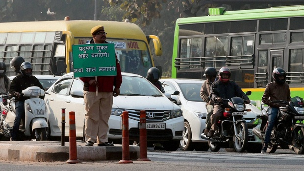 A policeman holding a sign that reads, "make it a pollution free city, enjoy your new year"