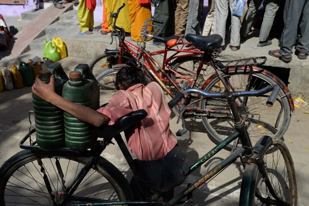 <p>A child awaits her turn outside a shop selling kerosene at a subsidised price in Alwar district, Rajasthan [image by Sajjad Hussain, AFP]</p>