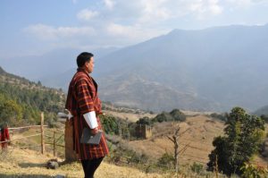 <p>A local representative inspects fallow fields in the town of Phangyul, Bhutan [image by Dawa Gyelmo]</p>