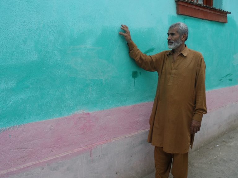 Saleem Khan shows exterior of a straw bale wall that is rendered with earthen plaster stucco [image by Aamir Saeed]
