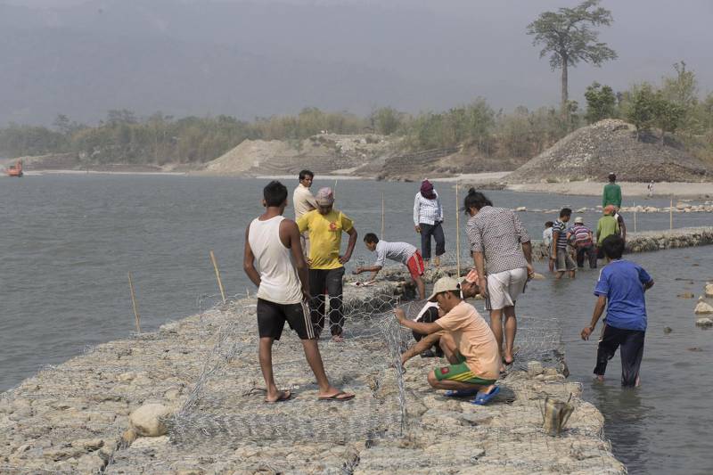Workers rebuild gabion wall to replace the vulnarable old wall to protect villages from flood at Koshi Barrage. Sunsari, Nepal [image by Nabin Baral]	