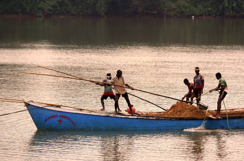 five men sand mining from a river near Mangalore