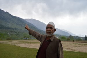 <p>A Kashmiri man near a Budgam forest shows the degradation caused to forests over the past few decades [image by:  Athar Parvaiz]</p>
