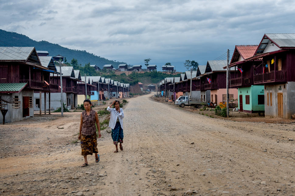Residents of Samaky Sai, or "United Village", walk along on e of the camp's main roads