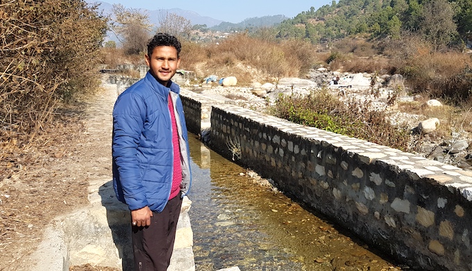 Bhupendra Singh Bisht shows a water channel (gul) that flows from the Gagas river and irrigates farms in the valley [image by: Hridayesh Joshi]