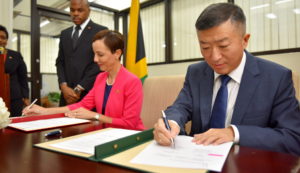 <p>O embaixador chinês na Jamaica Tian Qi (à direita) assina um acordo sobre a iniciativa Um Cinturão, Uma Rota com a chanceler jamaicana Kamina Johnson-Smith (imagem: Yomo Hutchinson)</p>