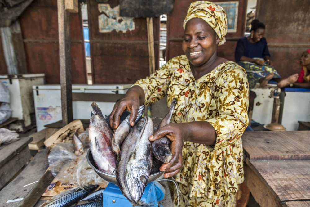A fish seller weighing imported frozen fish for sale at Ijora frozen food market in Lagos, Nigeria