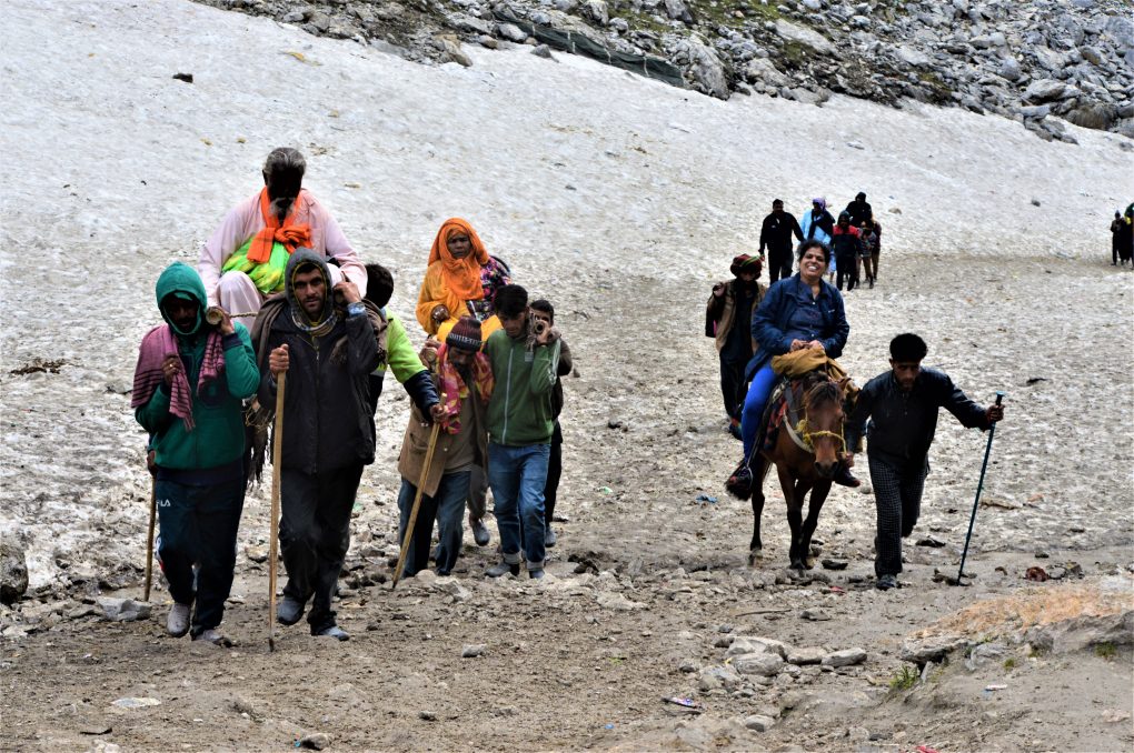 A pilgrim expresses her happiness as she, along with other pilgrims, is just a few hundred meters away from the Amarnath Cave. Pilgrims trek on accumulated snow for a long distance via Pahalgam to get to the cave [image by: Athar Parvaiz]