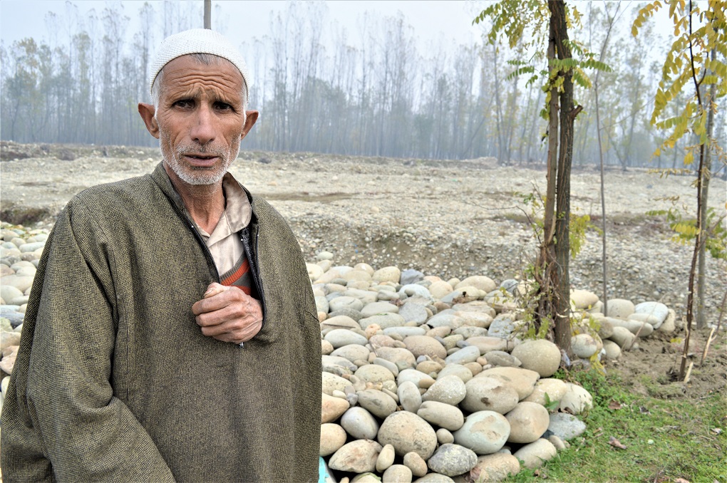 A man standing on the bank of a tributary of Jhelum in south Kashmir, Vishu. In autumn and winters, Jhelum's tributaries have extremely low flows [image by: Athar Parvaiz]