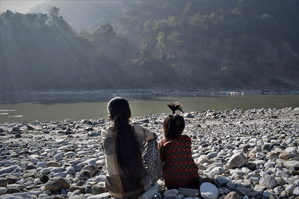 Two girls look across the Mahakali at India