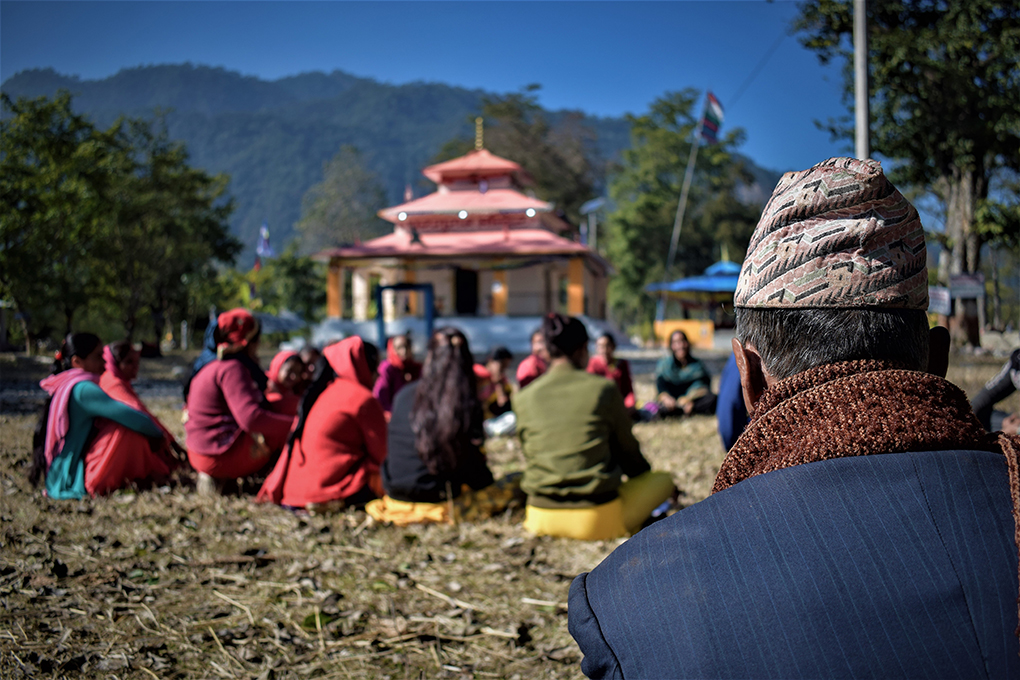A WEC meets on the grounds of the village temple, while a man looks on