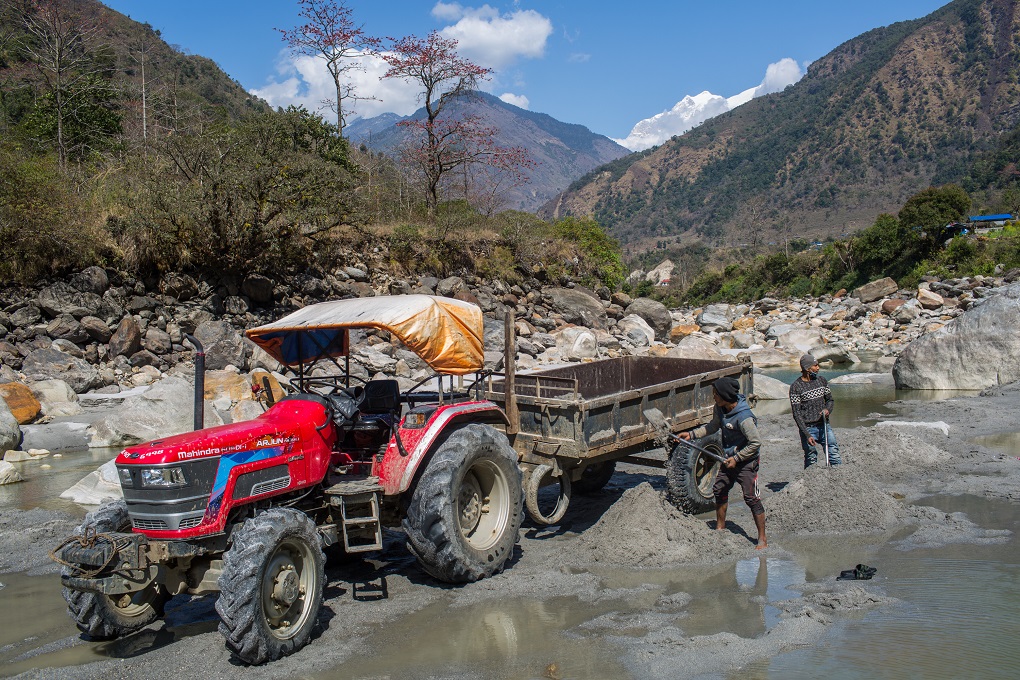 A truck and two workers extract sand from the dry bed of the Marsyangdi downstream of the dam of the 50 MW Upper Marsyangdi A hydro project in Nygdi