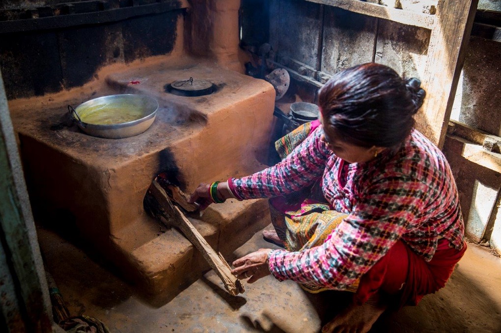 Woman burning cooking food using burning wood.  For many women in the HKH region the only form of energy is burning wood or biomass [image courtesy: ICIMOD]