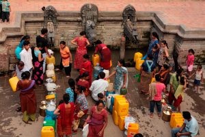 <p>People stand for hours to fill their buckets and plastic containers from the ancient stone spouts or hitis in Patan, Nepal. (Majority World CIC / Alamy)</p>