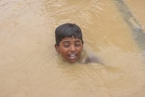 <p>A boy swims through a flooded street in Ramgaduwa in southern Nepal (Image: Munna Saraff)</p>