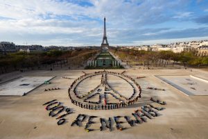 100% renewable sign in front of the Eiffel Tower, champs de mars
