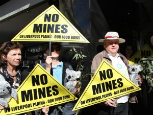 china mining protests. People hold signs saying 'no mines'