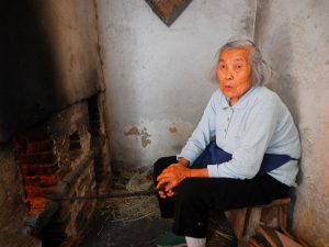 woman sitting down coal burning in Beijing