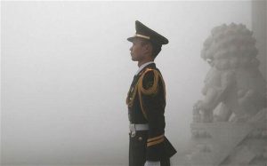 A Chinese soldier stands guard in central Beijing. Persistent smog over several days has triggered the city's first ever air quality 'red alert