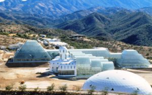 <p>The Biosphere 2 facility in southern Arizona. The white domed structure is one of two “lungs” (expansion chambers) connected to the main structure by air tunnels. In the distance is the Biospheric Research and Development complex where much of the initial system research, training for participants, and raising of plants, animals and insects occurred. Biosphere 2 included 30,000 tonnes of soil, 3800 species of plants and animals, and eight humans (Image: Gill C Kenny).</p>