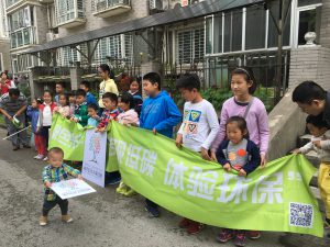Children hold a banner outside the home of Helen Ni in Shanghai. The roof shading the patio is covered with solar panels. (Image: Helen Ni)
