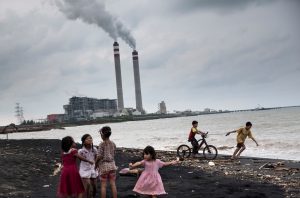 <p>Children play by the beach near a coal power plant in Jepara, Central Java, Indonesia, oblivious to the possible threats to their health. The country is currently rolling back its commitment to reduce fossil fuel subsidies. (Image by&nbsp;Kemal Jufri / Greenpeace)</p>