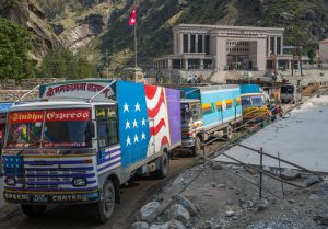 <p>Trucks entering Nepal from China at Rasuwa Gadhi inland port. The Chinese Customs and Immigration office is in the background. (Images:&nbsp;Nabin Baral)</p>