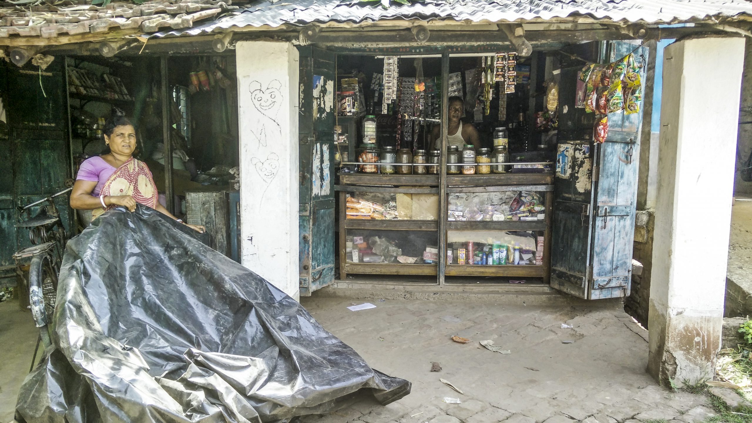 <p>A couple running a small shop in a village near the confluence of the Damodar with the Ganga. We were told that it hasn’t been too long since products such as biscuits were sold out of large containers instead of small plastic packets (Image: Siddharth Agarwal)</p>