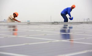 Workers install solar panels in Shanghai. China will need to raise the share of renewables in its energy mix to curb coal and peak CO2. (Image by Jiri Rezac/The Climate Group) 