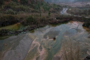 <p>雨季，浸矿池和矿山上残留的化学品顺着地势流向矿区内的大小河流。摄影：刘虹桥</p>