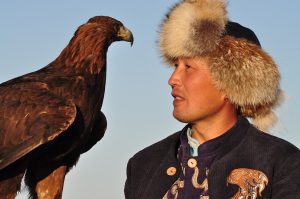 <p>Local culture and nature are deeply intertwined for a hunter and his eagle near the shore of Lake Issyk Kul. Building on cultural traditions, they are now also engaged in family-based ecotourism operations [image courtesy: Marc Foggin]</p>