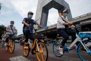People ride shared bicycles past the CCTV headquarters in the Central Business District following an outbreak of the coronavirus disease (COVID-19) in Beijing, China, August 4, 2020. Picture taken August 4, 2020