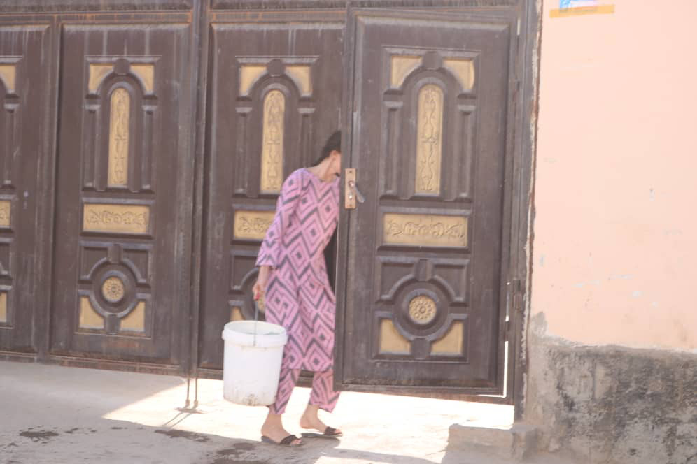 A Dushanbe resident carries water home [Image by: Firuza Karimova]