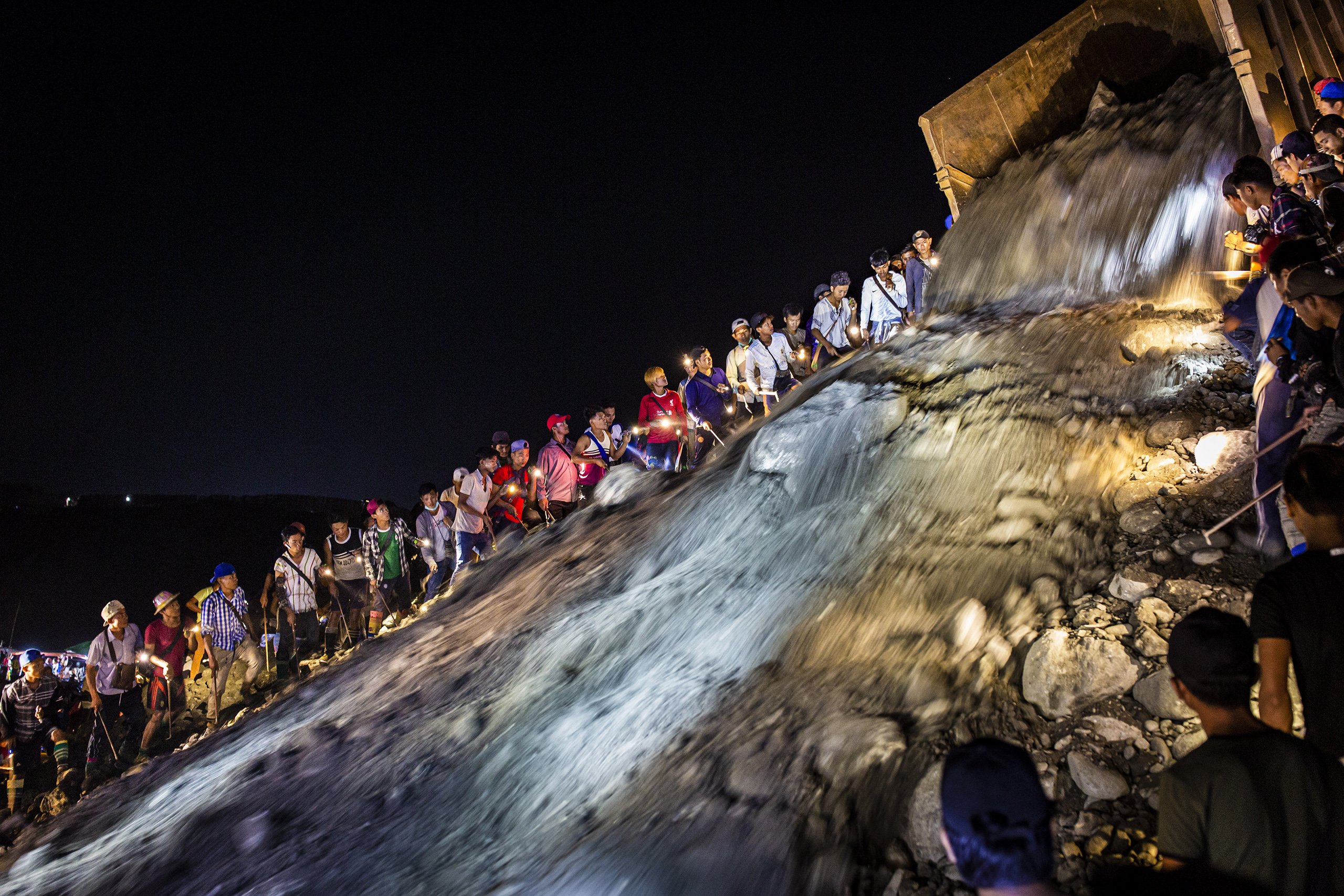 Informal miners wait while a truck dumps tailings, waste from industrial-scale operations at a nearby jade mine (Image © Hkun Lat)