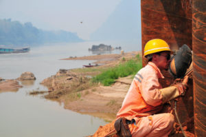 A Chinese welder at work on a bridge over the Mekong, part of the China–Laos high-speed railway