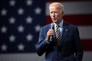 Joe Biden speaking in front of a US flag