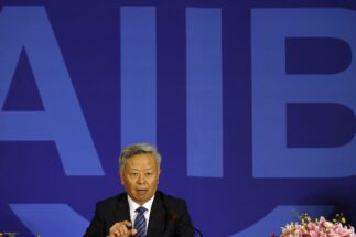 O presidente do Banco Asiático de Investimento em Infraestrutura com uma placa do AIIB atrás dele.