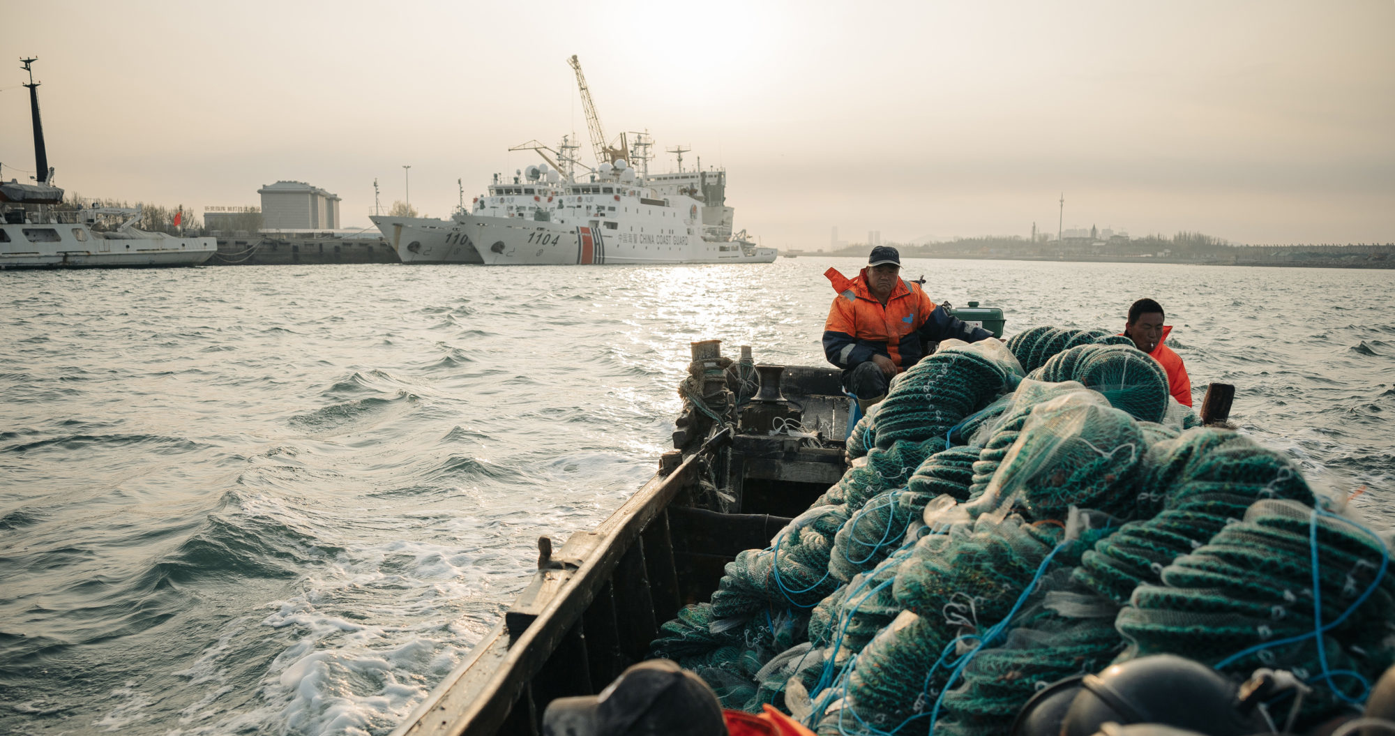 <p>The Shandong authorities are pushing “marine ranching” as an alternative to coastal aquaculture. Skipper Li Zhonghua (centre) and two employees are on their way to their offshore ranch (Image: Liu Yuyang)</p>