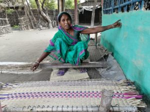 <p>55-year-old Rudridevi Sardar making a mat in front of her home. She sustains herself with mat-making using wetland materials from Koshi Tappu Wildlife Reserve [image by: Birat Anupam]</p>