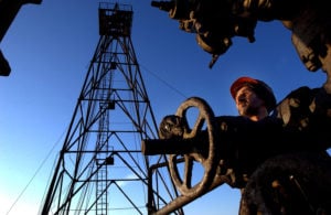 An oil worker repairs a pipe on an oil field in the Caspian Sea in petrostate Azerbaijan