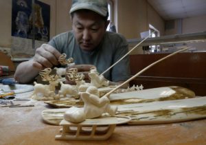 <p>An entrepreneur carves figures from mammoth tusk in Yakutsk. After decades of profit, the mammoth ivory business is in decline in Siberia, mainly due to China’s 2018 ban on elephant ivory. (Image: Sergei Karpukhin / Alamy)</p>