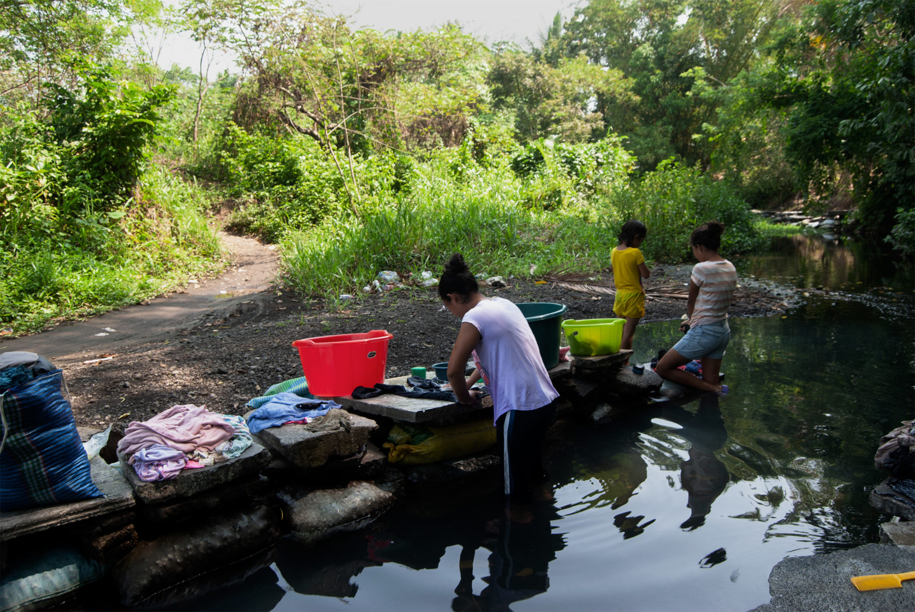 Elicita Guzmán lava su ropa en el río La Noria con sus hijas 
