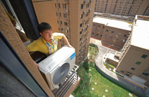 man installs an air conditioner, which is