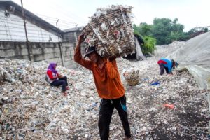 People collect plastic scraps and paper to take to a local factory in Indonesia