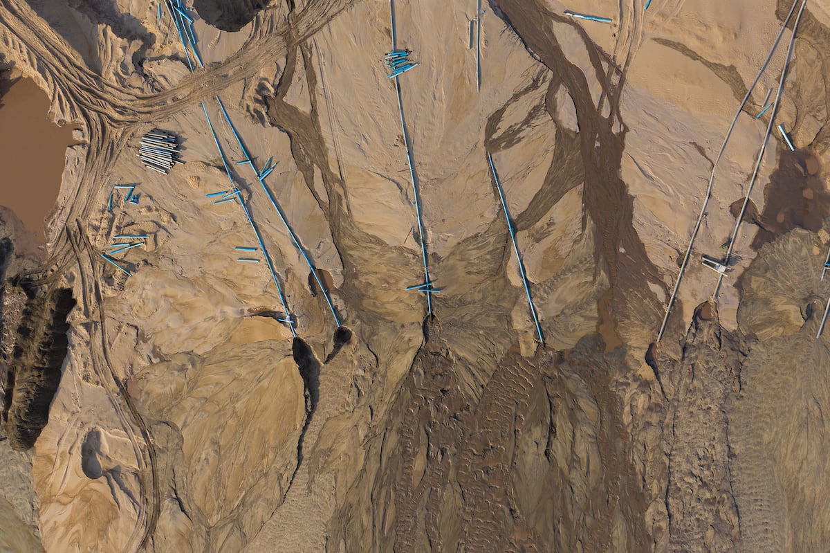 <p>Pipes pump sand dredged from the Mekong River onto an area of land being reclaimed for property development on the outskirts of the Cambodian capital, Phnom Penh (Image © Thomas Cristofoletti / Ruom)</p>