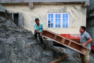 Men retrieve possessions from a house hit by flash flooding along the bank of Melamchi River in Sindhupalchok, Nepal, Navesh Chitrakar
